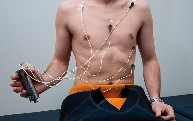 Man's bare chest has electrode pads on it