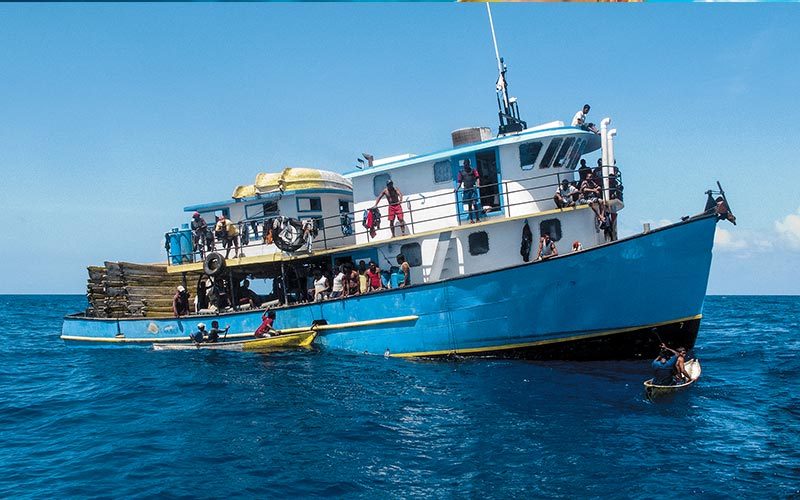 Blue-bottomed lobster boat full of fishermen