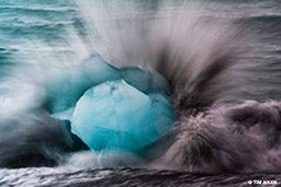 Iceberg is surrounded by crashing waves