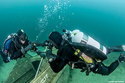 Two divers share a regulator