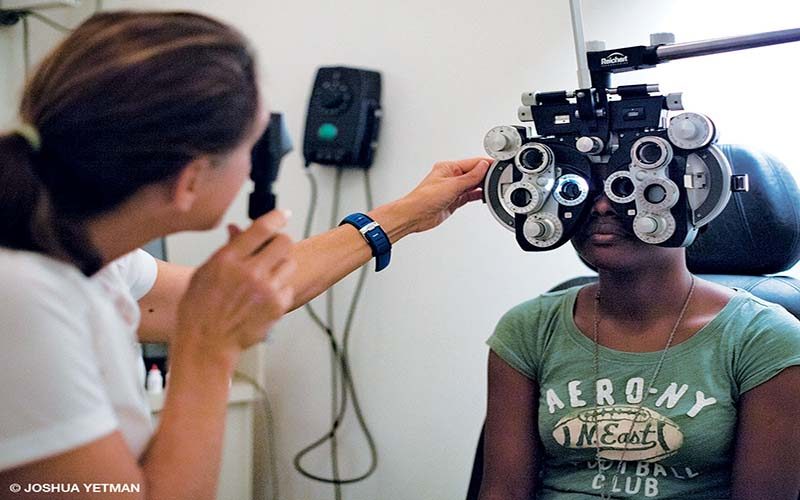 An ophthalmologist performs an eye test on a little girl in Grenada