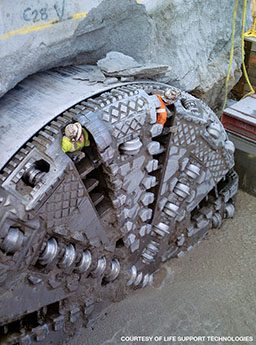 Workers are inside a tunnel boring machine for inspection