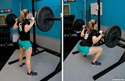 A woman in teal shorts performs a barbell back squat