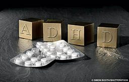 Letter blocks depict the letters ADHD and there are pills in the foreground
