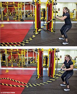 A personal trainer demonstrates the battle rope snake by shaking the two ropes back and forth