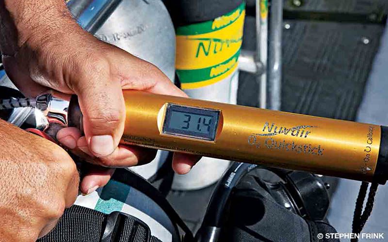 A diver is preparing his nitrox cylinders.