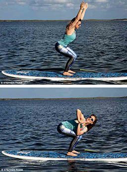 A personal trainer stands on paddleboard and demonstrates twisting chair pose. She's squatting down.