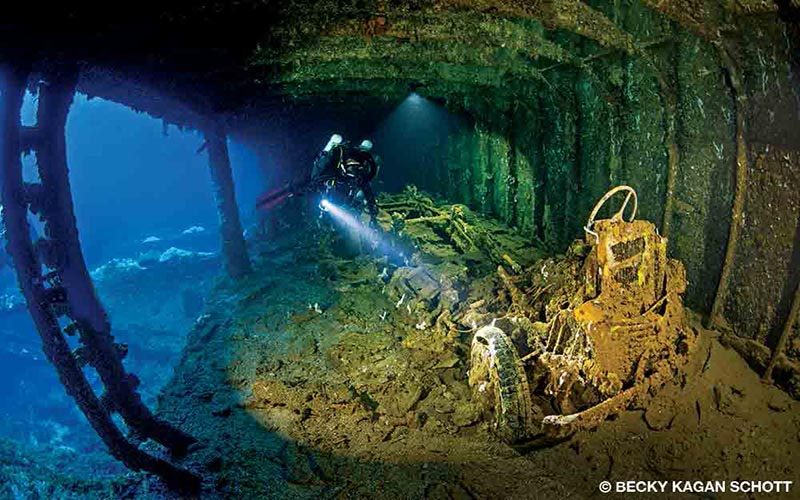 A diver explores some sunken equipment that contains aircraft parts, trucks and more.