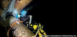 A commercial diver conducts wet welding operations.