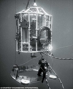 A diver locks out of a three-man diving bell.
