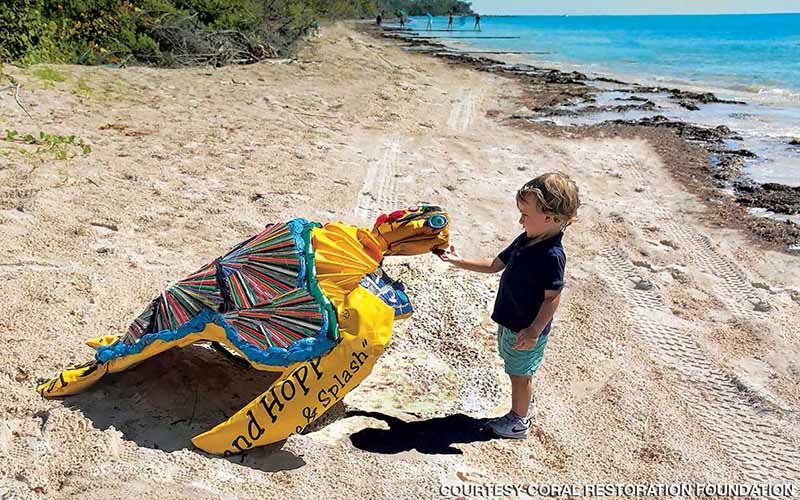 A little boy poses with the colorful turtle art