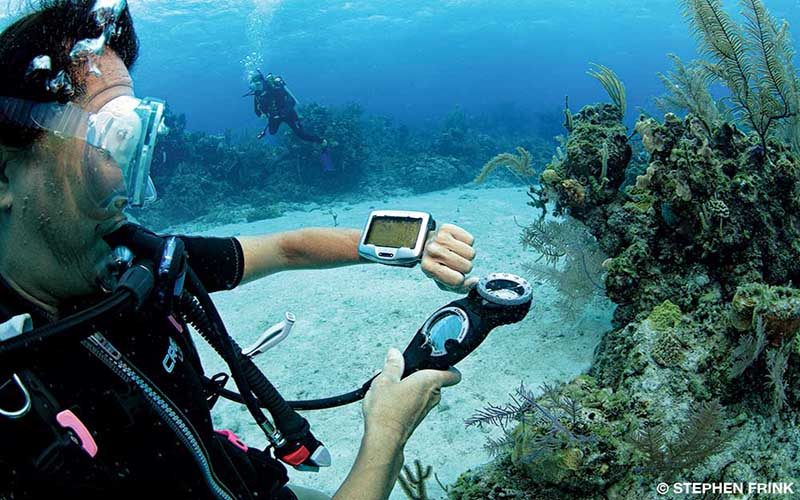 Diver checks dive computer strapped onto left arm