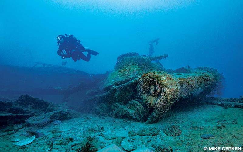A diver hovers over a Japanese battle tank at 160 feet on the forward deck of the San Francisco Maru, a premier dive site in Chuuk.