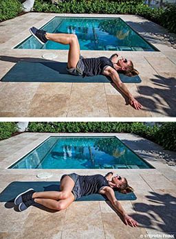 A female personal trainer lies on her back and is twisting her lower half