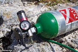A green DAN oxygen tank lays on its side and can be used to administer emergency oxygen.