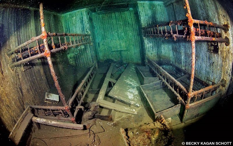 The inside of the Emperor shipwreck shows some old bunk beds and a pair of boots.