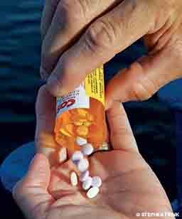 A diver counts out some pills into the palm of his hand.