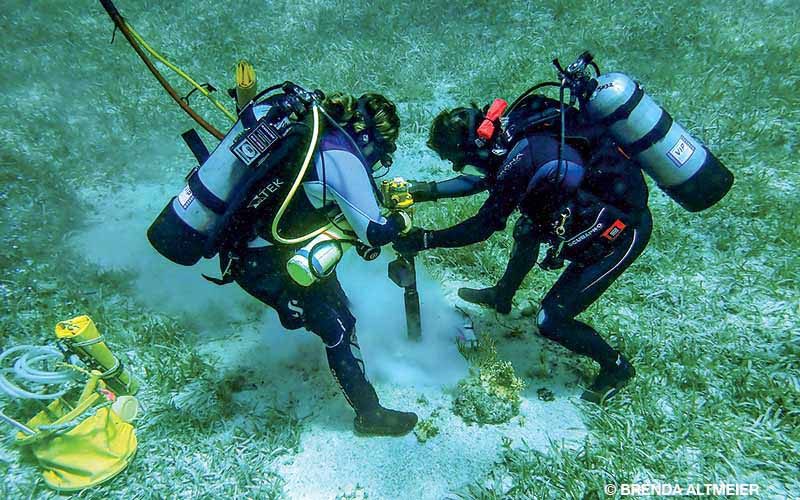 Divers drill seafloor to install a mooring buoy system