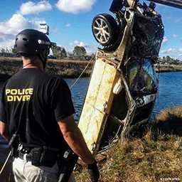A car is removed from the water by police diving crew