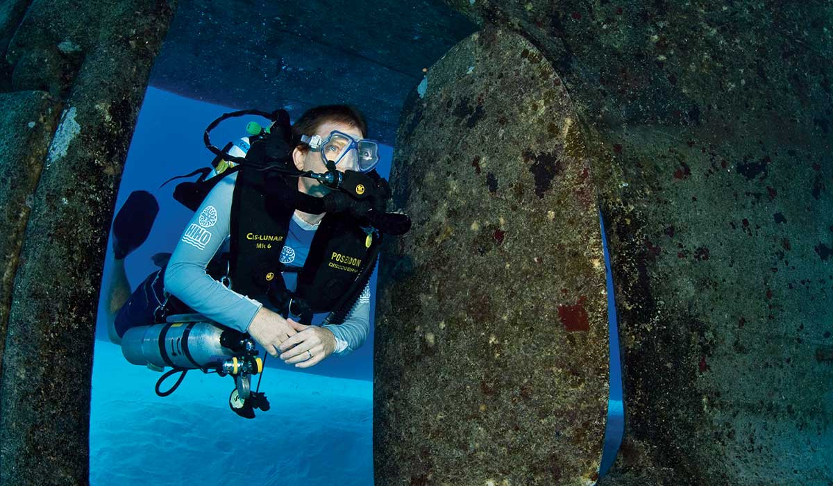 A tech diver floats through a wreck