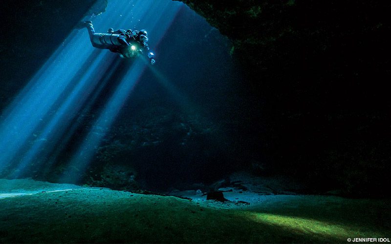 One diver enters into a dark hole called Jug Hole