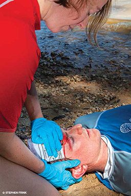 EMT holds compress to man's bleeding head