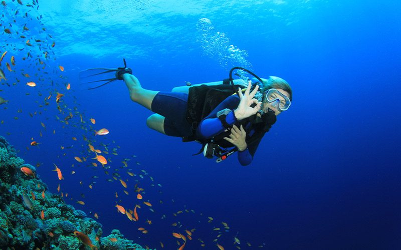 Female diver gives OK sign to camera 800x500