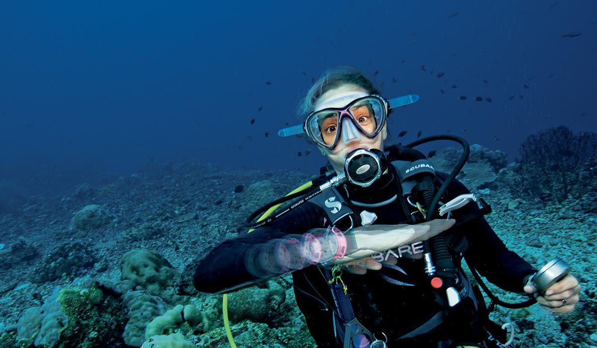 Female diver makes an out-of-air hand signal