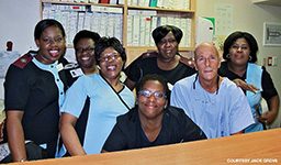 Bald man poses with hospital staff
