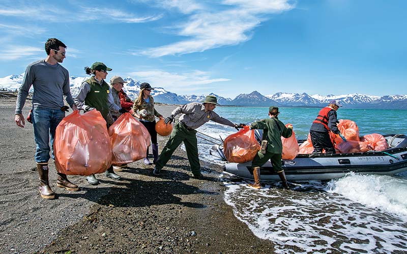 Team of trash collectors work together on beach