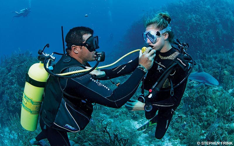 Two divers practice sharing a regulator