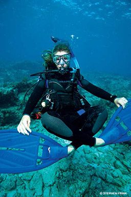 A buoyant diver is sitting crisscross and appears floating underwater