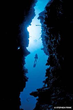 A diver in between a deep crevice