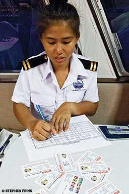 Boat crew member fills out forms and paperwork 