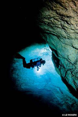 Cave diver illuminated by a bright strobe light their holding