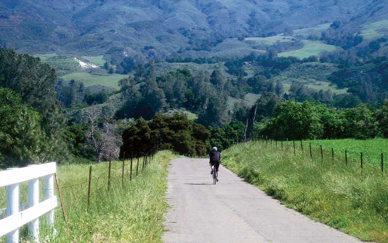 Cyclist on an open mountain, scenic road