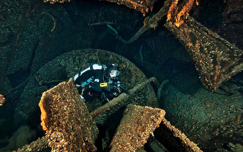 Diver explores the engine room of a shipwreck