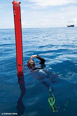 Diver floats next to red buoy marker