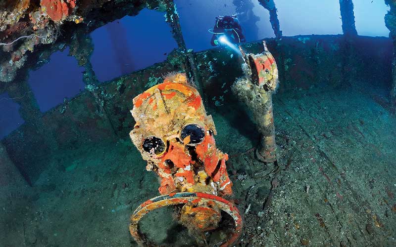 Diver looks into a sunken ship