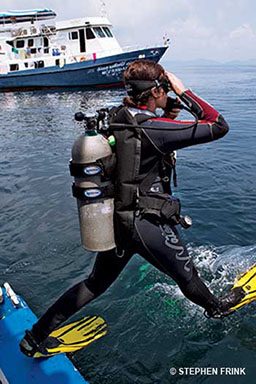 Diver takes step off boat and into water