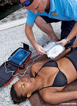 EMT gets AED pad ready for unconscious woman