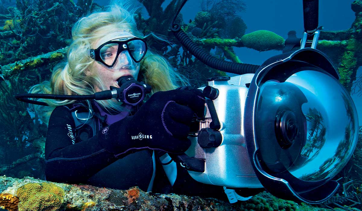 Female diver holds a camera