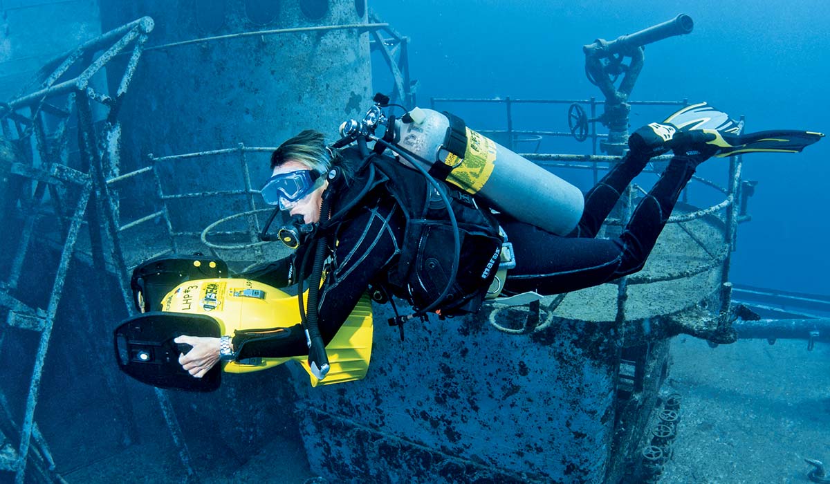 Female diver holds a yellow propulsion vehicle