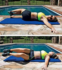 Female personal trainer lies on back, knees bent, and is rotating bent knees away from face