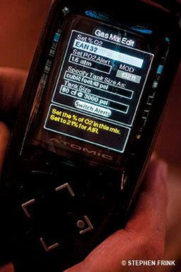 Hands hold a dive computer