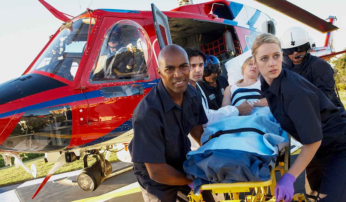 Helicopter crew work together to rush a stretcher to emergency care