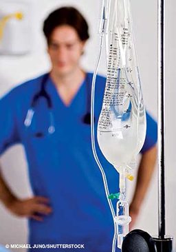 IV bag with a scrubbed nurse in the background