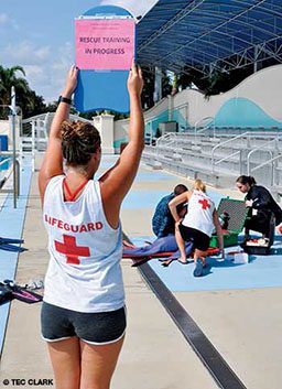 Lifeguard holds up a pink sign