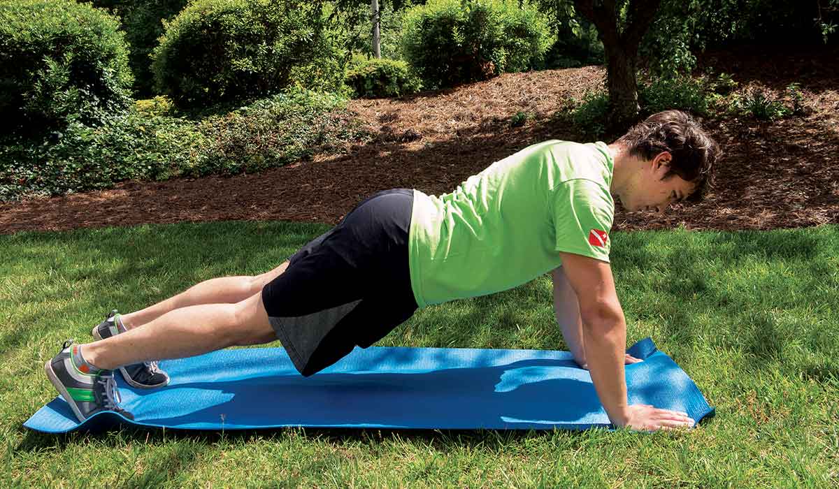 Man in green shirt holds a plank position