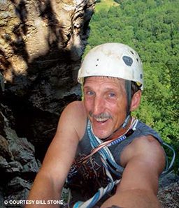 Mustached man takes a selfie while rock climbing